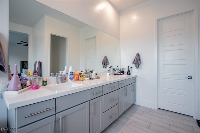 bathroom featuring wood-type flooring, vanity, and ceiling fan