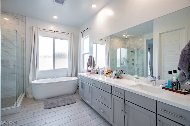 bathroom with wood-type flooring, vanity, and separate shower and tub