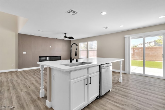 kitchen with white cabinets, ceiling fan, a center island with sink, stainless steel dishwasher, and sink