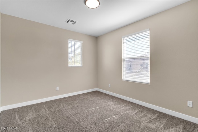 carpeted spare room featuring plenty of natural light