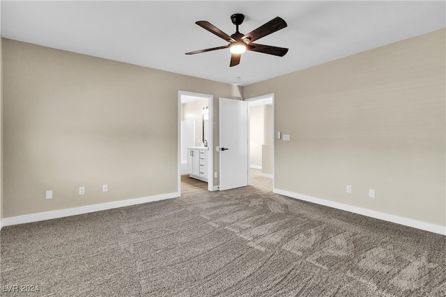 unfurnished bedroom featuring ceiling fan, ensuite bath, and carpet