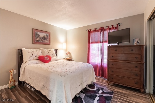 bedroom with dark hardwood / wood-style floors