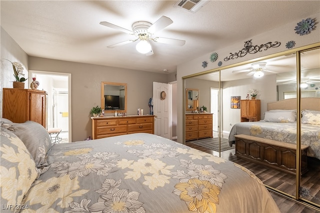 bedroom with a closet, multiple windows, ceiling fan, and dark hardwood / wood-style floors