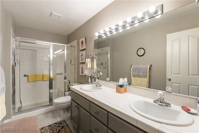 bathroom with vanity, toilet, an enclosed shower, and tile patterned floors