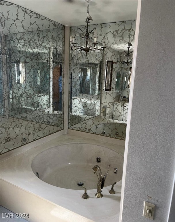 bathroom featuring a bathing tub and a notable chandelier