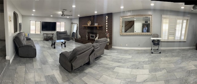 living room featuring a brick fireplace, plenty of natural light, and ceiling fan