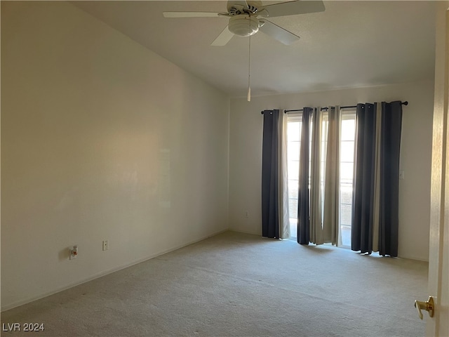 carpeted spare room featuring ceiling fan