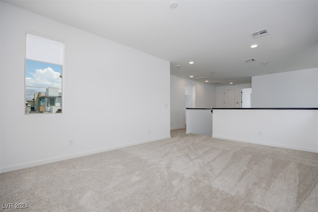 unfurnished living room with light colored carpet