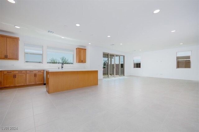 kitchen featuring a center island, light tile patterned floors, and sink