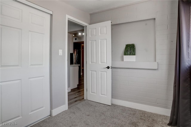 unfurnished bedroom with light carpet and a closet