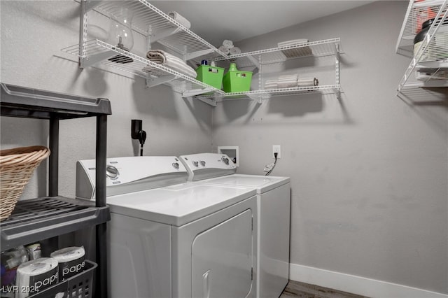 clothes washing area with hardwood / wood-style flooring and washing machine and dryer