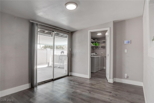 spare room featuring dark wood-type flooring, a textured ceiling, and washer and clothes dryer