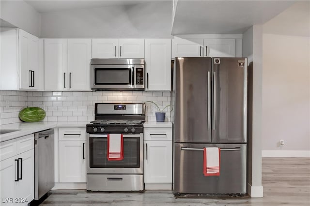 kitchen featuring white cabinets, decorative backsplash, light hardwood / wood-style floors, and appliances with stainless steel finishes