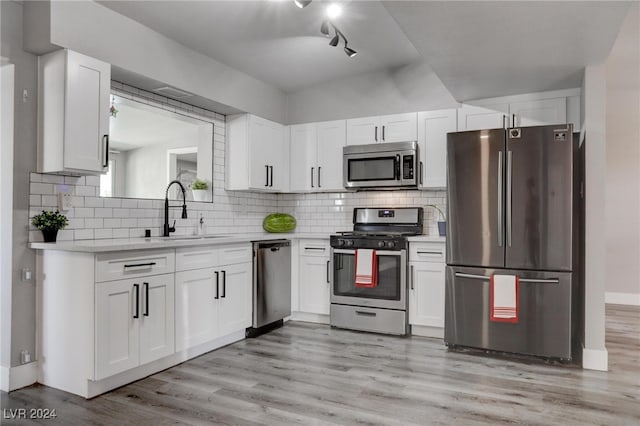 kitchen featuring sink, white cabinetry, backsplash, and stainless steel appliances