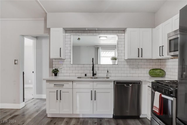 kitchen featuring sink, tasteful backsplash, white cabinetry, and stainless steel appliances