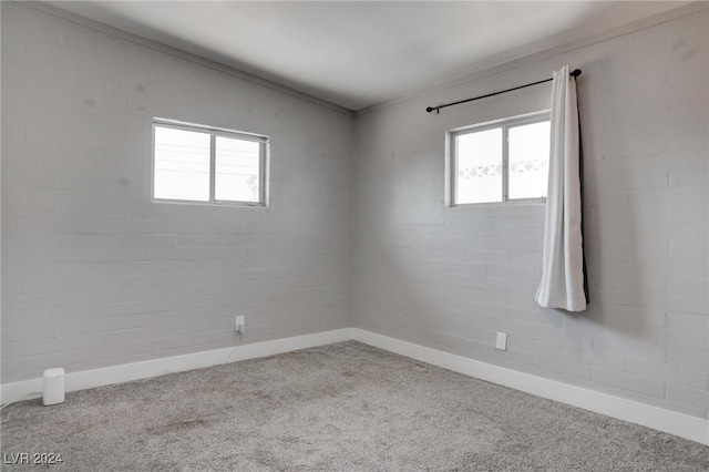 empty room featuring vaulted ceiling, brick wall, and carpet floors