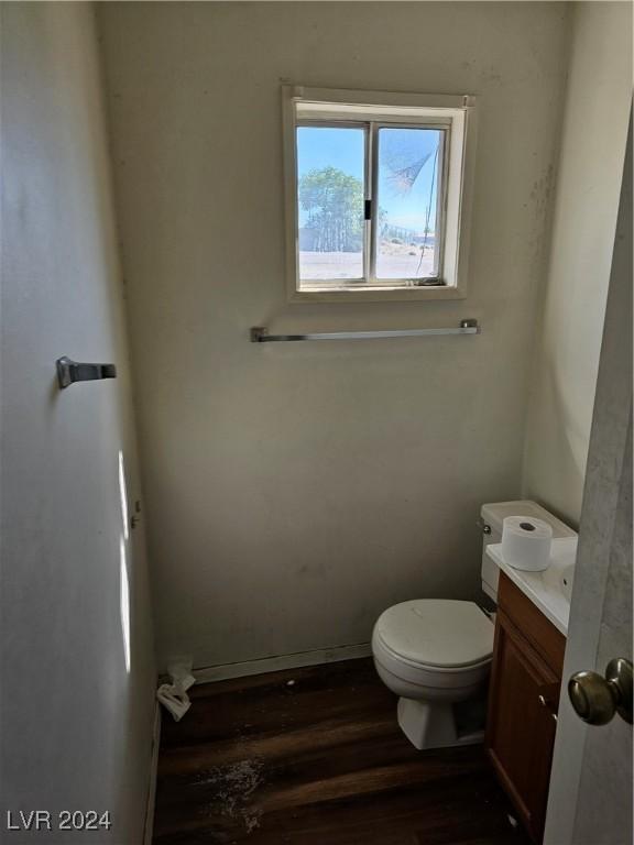 310 Arizona St, Tonopah, NV 89049 - half bathroom with wood finished floors, toilet, baseboards, and vanity