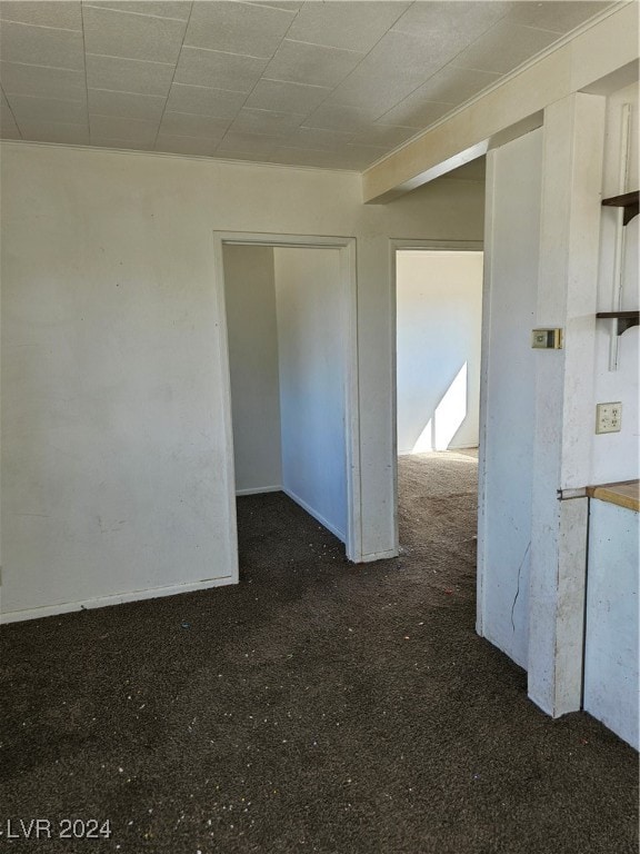 spare room with dark carpet