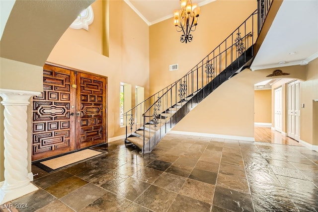 entrance foyer with ornamental molding and a high ceiling