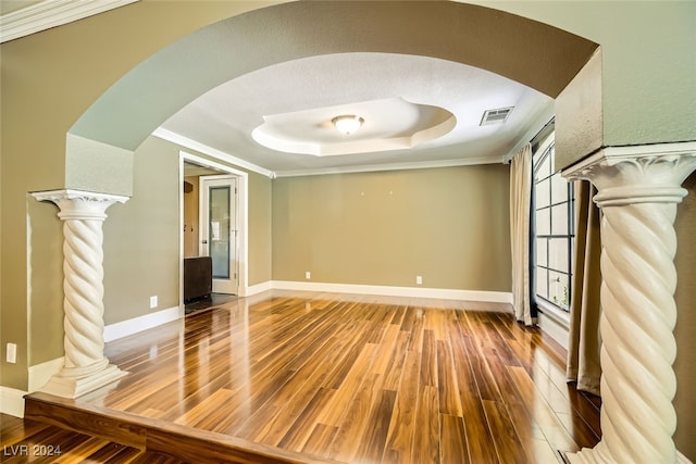 empty room featuring hardwood / wood-style flooring, a raised ceiling, crown molding, and a textured ceiling