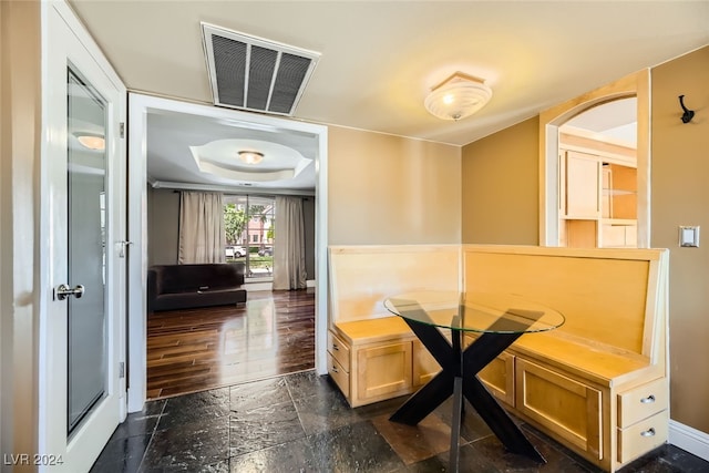 dining room with a tray ceiling and dark hardwood / wood-style flooring