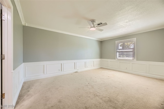 unfurnished room with carpet, ceiling fan, and crown molding