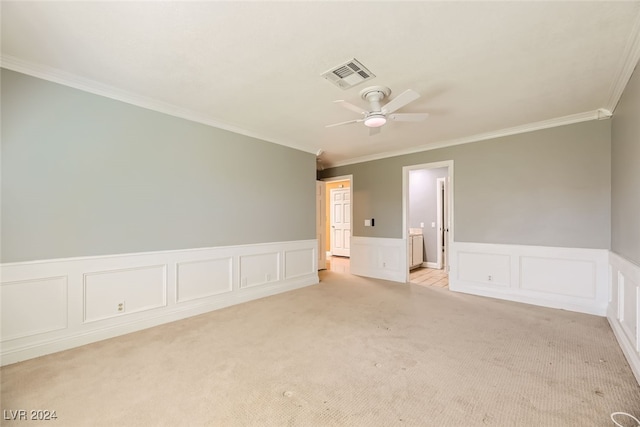 empty room with ceiling fan, light colored carpet, and crown molding