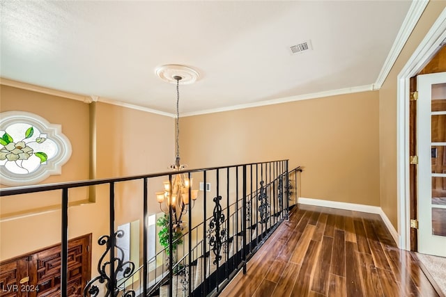 corridor featuring a chandelier, dark wood-type flooring, and crown molding