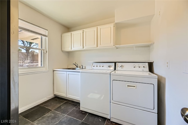 clothes washing area with cabinets, washer and dryer, and sink