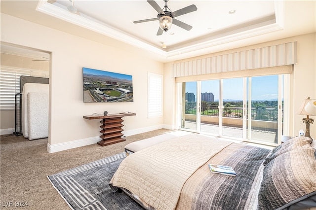 bedroom featuring carpet, ceiling fan, access to exterior, and a tray ceiling