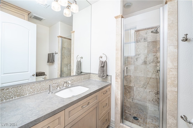 bathroom with vanity, an enclosed shower, and a notable chandelier