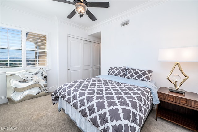 carpeted bedroom with a closet, ornamental molding, and ceiling fan