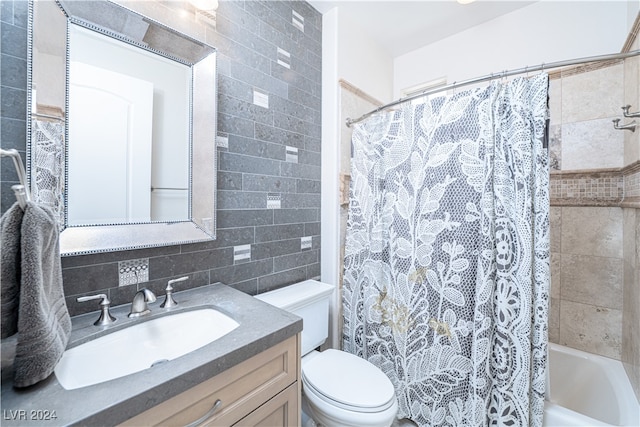 full bathroom featuring shower / bath combo, tasteful backsplash, toilet, vanity, and tile walls