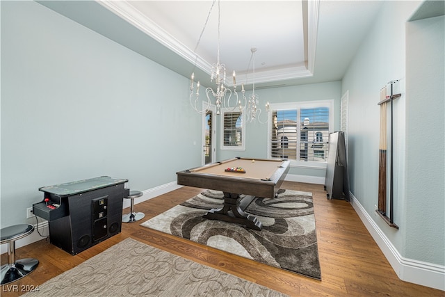 game room with an inviting chandelier, a raised ceiling, billiards, hardwood / wood-style flooring, and ornamental molding