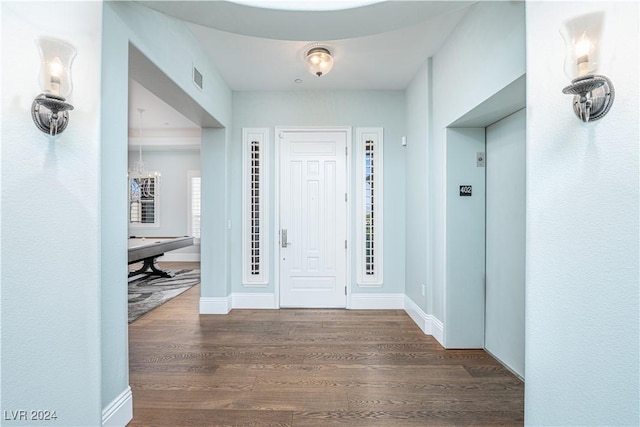 foyer with dark hardwood / wood-style flooring and a chandelier