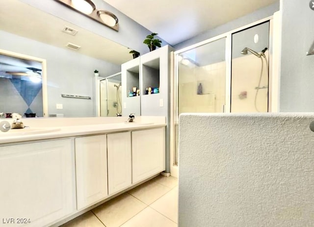 bathroom with walk in shower, vanity, and tile patterned floors