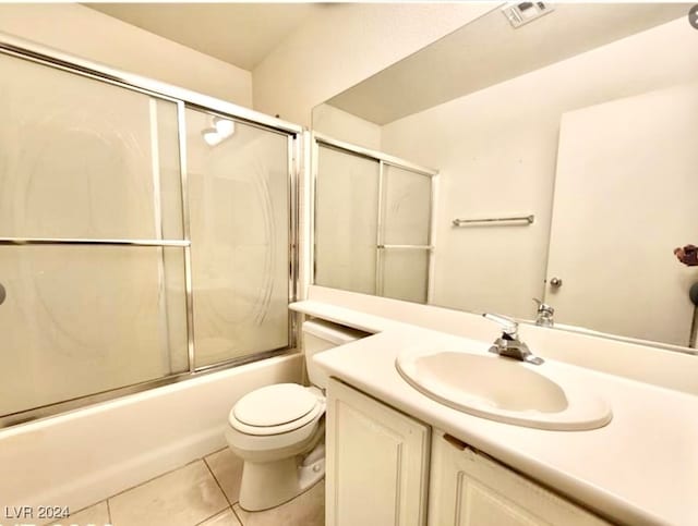 full bathroom with bath / shower combo with glass door, vanity, toilet, and tile patterned floors