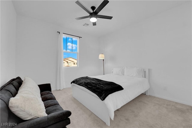 bedroom featuring light carpet, baseboards, visible vents, and a ceiling fan