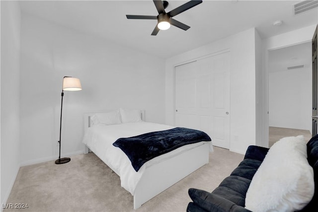 bedroom with light carpet, baseboards, visible vents, and a closet