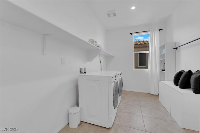 clothes washing area featuring laundry area, baseboards, washer and clothes dryer, and light tile patterned flooring