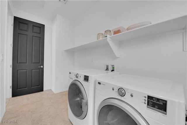 laundry area featuring washer and dryer, laundry area, light tile patterned flooring, and baseboards