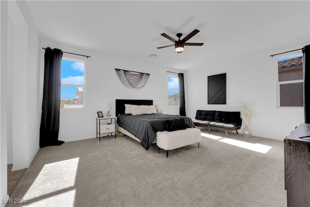 bedroom featuring light carpet, ceiling fan, and visible vents