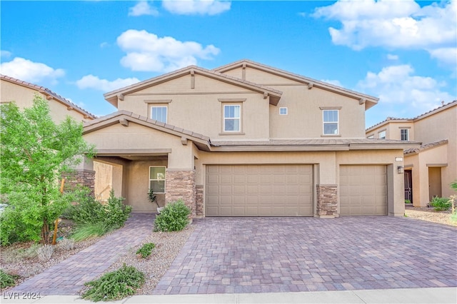 view of front of property with a garage, stone siding, decorative driveway, and stucco siding