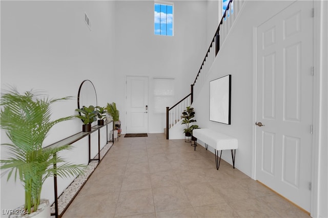 corridor with a towering ceiling and light tile patterned floors