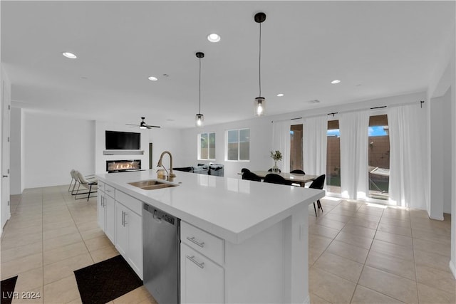 kitchen with a sink, white cabinets, open floor plan, light countertops, and stainless steel dishwasher