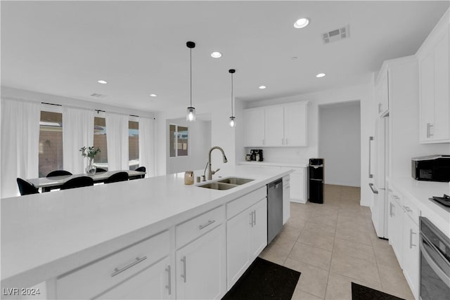 kitchen with stainless steel appliances, a sink, visible vents, light countertops, and hanging light fixtures