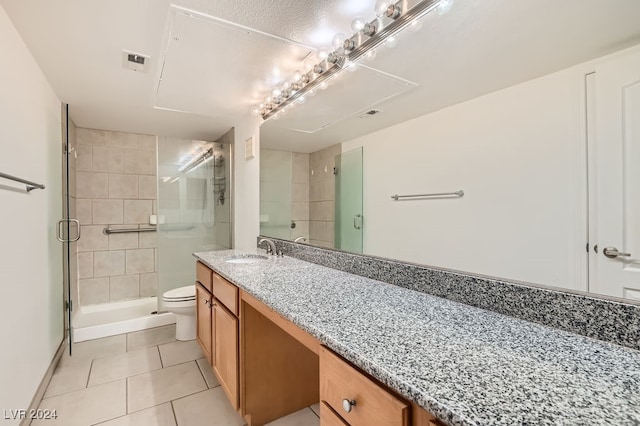 bathroom with tile patterned floors, an enclosed shower, vanity, and toilet