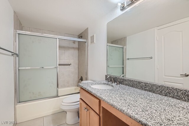 full bathroom with tile patterned flooring, enclosed tub / shower combo, vanity, and toilet