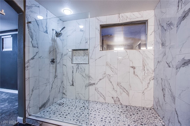 bathroom with a textured ceiling and an enclosed shower