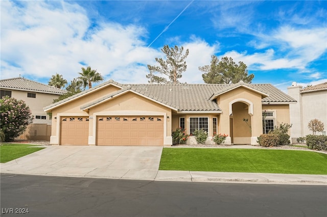 mediterranean / spanish home with a front yard and a garage